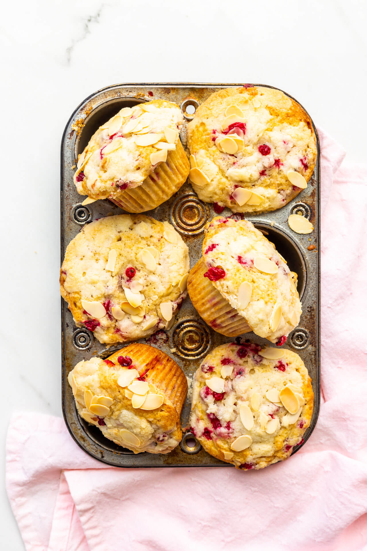 Vintage muffin pan with big red currant muffins 3 of them on their side to show muffin paper and bottom