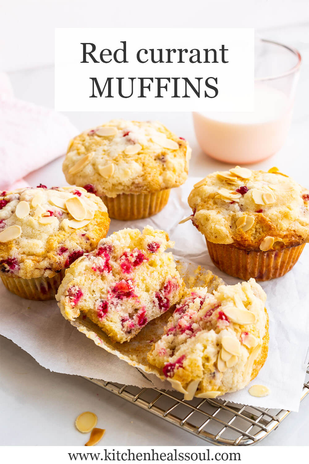 Red currant muffins cooling on rack with glass of milk in background, one muffin open in front