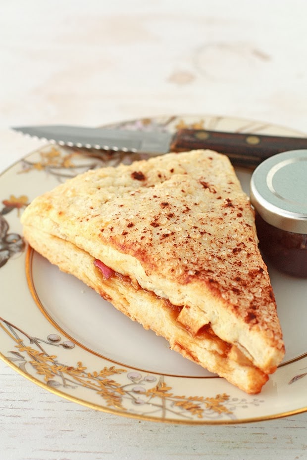 apple scones | kitchen heals soul apple stuffed scone on a plate with a little jar of jam and a knife