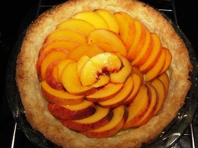 Fresh peaches arranged over blind-baked pie crust